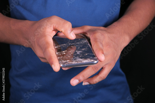 Close up of man hand holding broken smart phone.