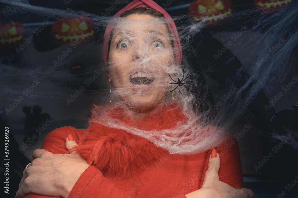 scared woman looking through the spider web. Helloween celebration concept