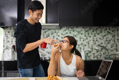 Asian couple teste together during eating pizza slice photo