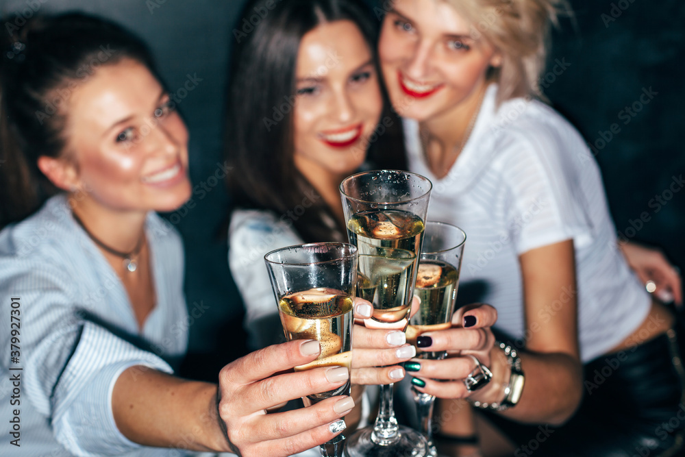 Three pretty young girls friends have fun together drinking champagne on party Three pretty young girls friends have fun together drinking champagne on party
