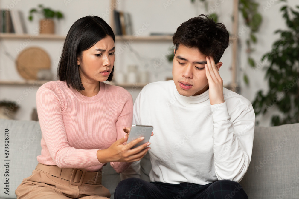 Chinese Girlfriend Showing Cheating Boyfriend His Cellphone Sitting At Home Chinese Girlfriend Showing Cheating Boyfriend His Cellphone Sitting At Home