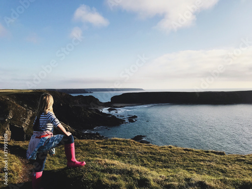 Female child standing over-looking the Welsh coast. photo