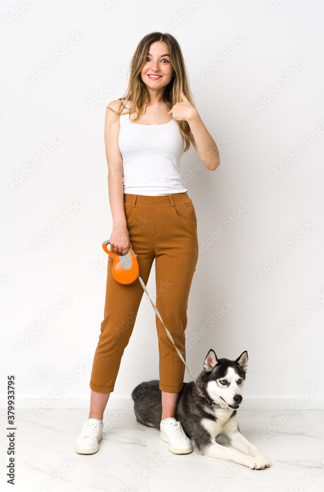 A full length young pretty woman with her dog with surprise facial expression A full length young pretty woman with her dog with surprise facial expression