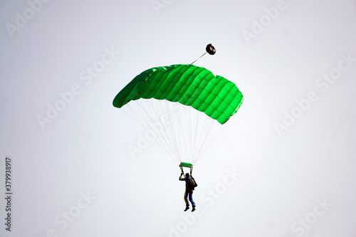 Parachutist jamped from an airplane uses a parachute to land.