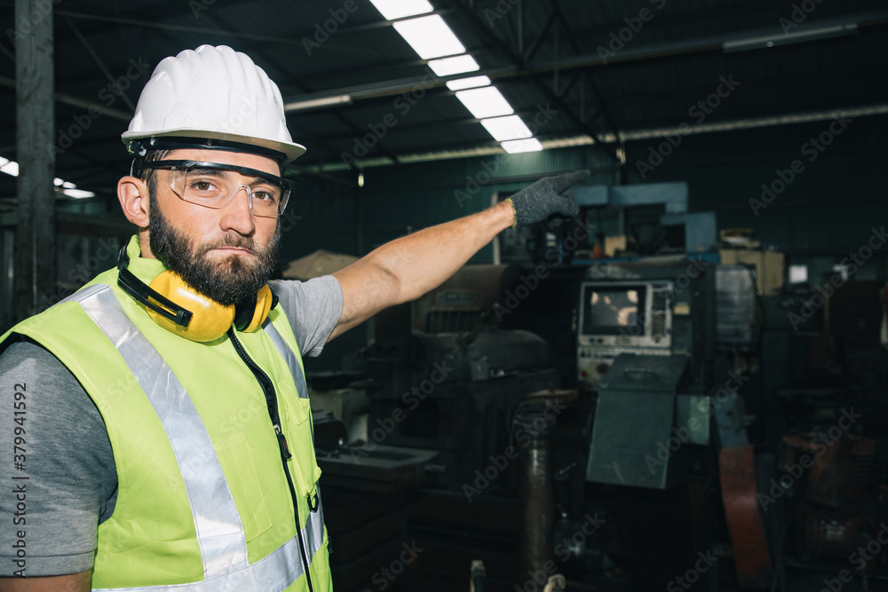 Portrait of professional technician engineer control machine with wrench in factory. He is a young businessman and owns a large turning mill. Portrait of professional technician engineer control machine with wrench in factory. He is a young businessman and owns a large turning mill.