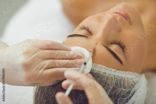 Fotografía Young woman recieving injection of anti-aging botox filler to forehead