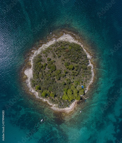 Vertical top view on a small island in the mediterrean sea close to the shore