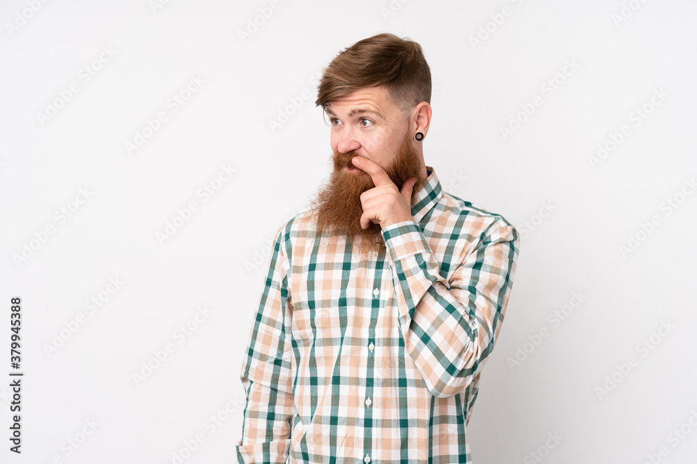 Redhead man with long beard over isolated white background looking to the side Redhead man with long beard over isolated white background looking to the side