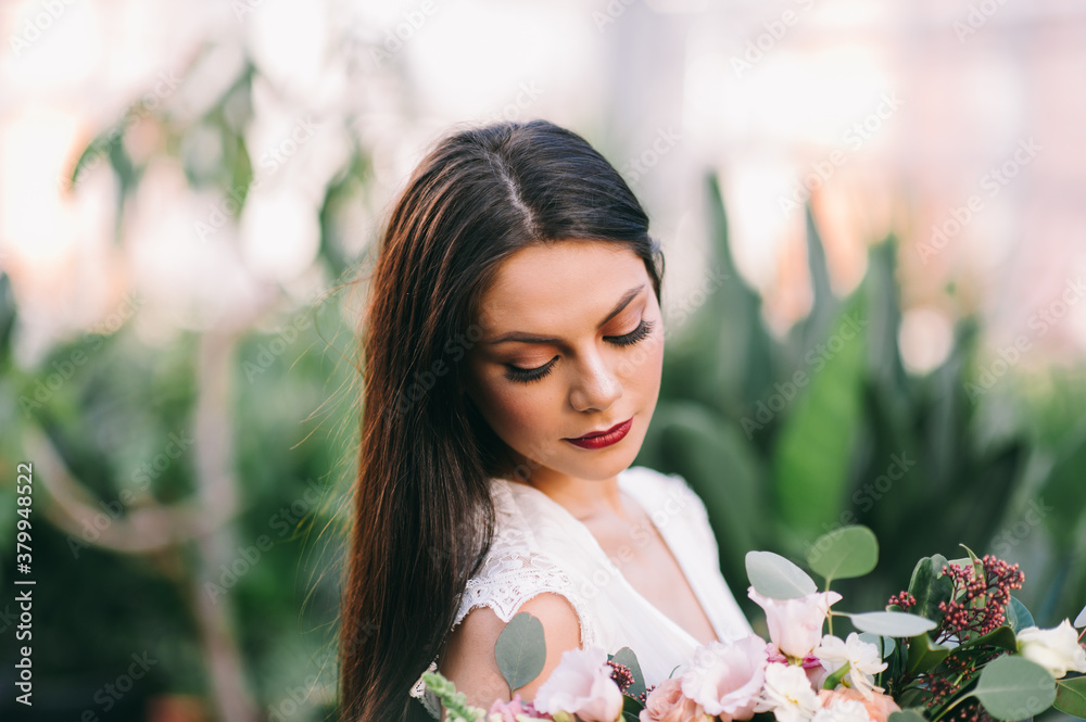 Long-haired brunette girl holds a flwers bouquet Long-haired brunette girl holds a flwers bouquet