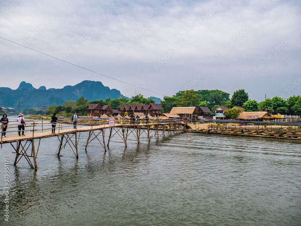 Vangvieng/lao-5 Dec 2017:Unacquainted People on the wooden bridge with beautiful view of Nam Song River in vangvieng Lao.Vangvieng City The famous holiday destination town in Lao.