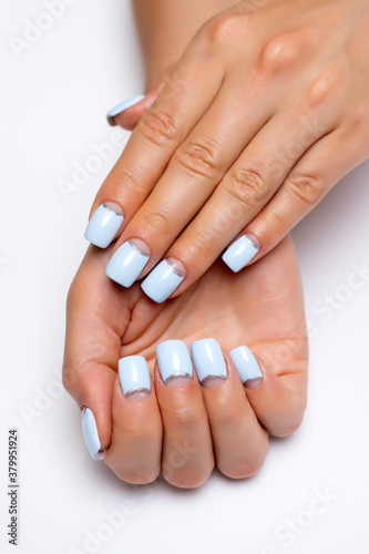 Blue moon manicure with a silver strip on long square nails close-up on a white background. Gel design.