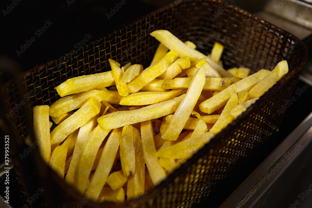 Foto de Raw uncooked french fries in deep fryer oven in fast food