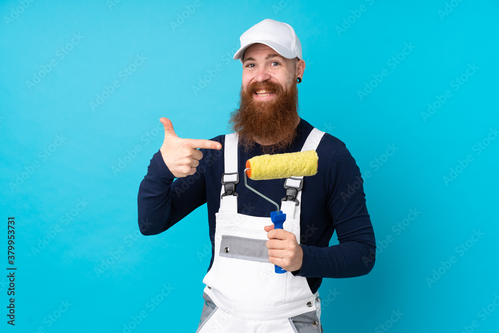 Painter man with long beard over isolated blue background pointing finger to the side