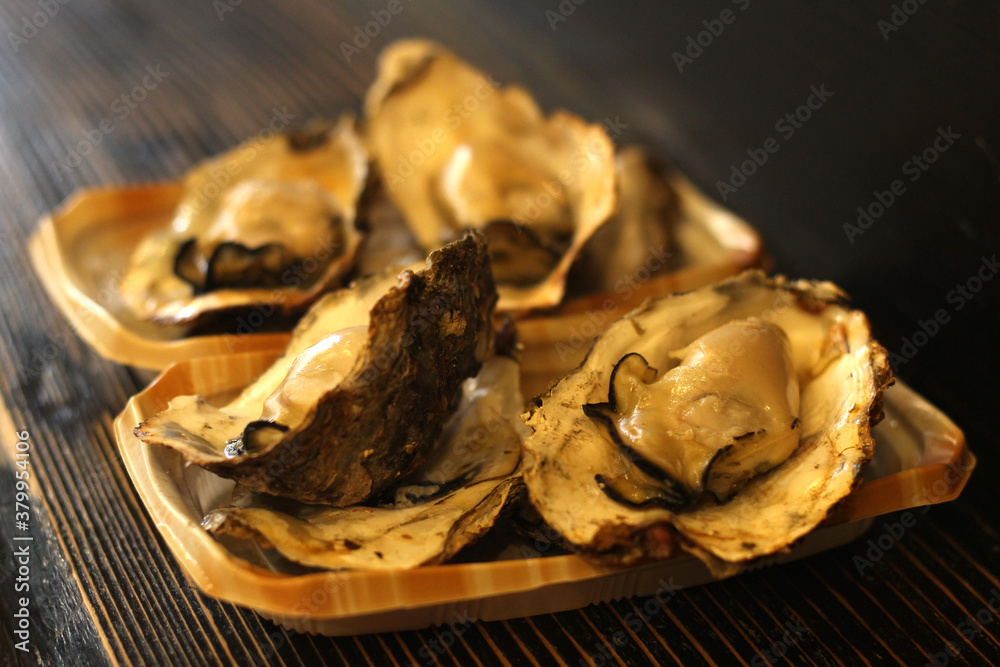 Close up of a plate of delicious grilled oysters, Hiroshima, Japan Close up of a plate of delicious grilled oysters, Hiroshima, Japan