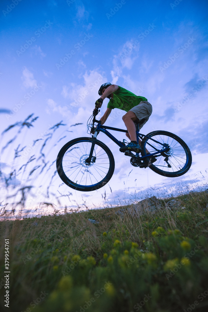 Caucasian man jumping with mountain bike off road Caucasian man jumping with mountain bike off road