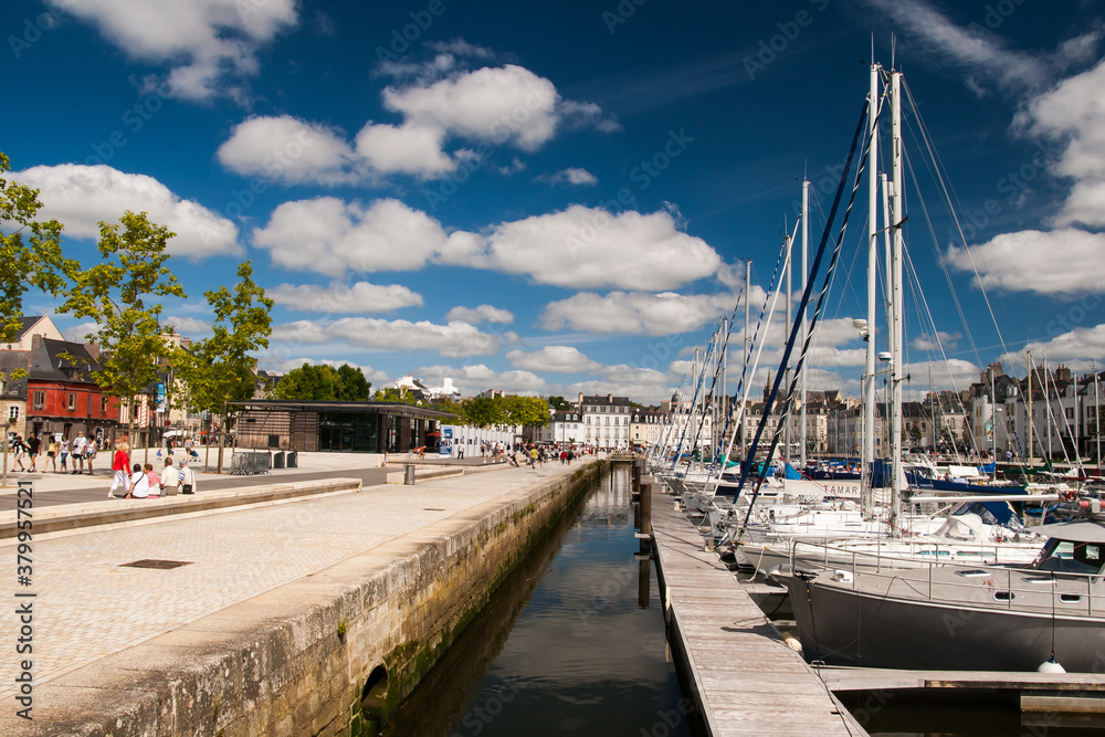 harbour with city promenade during perfect summer day, blue sky in france, brittany