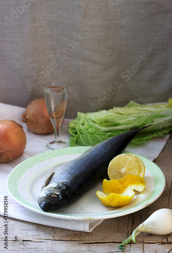 Still life of herring, lemon, onion and vodka. Rustic style.
