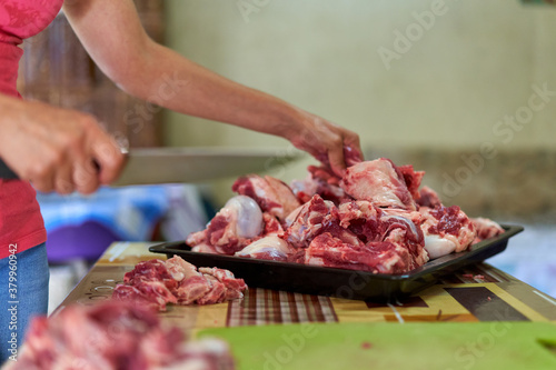 Woman's hand slicing beef on a wooden board