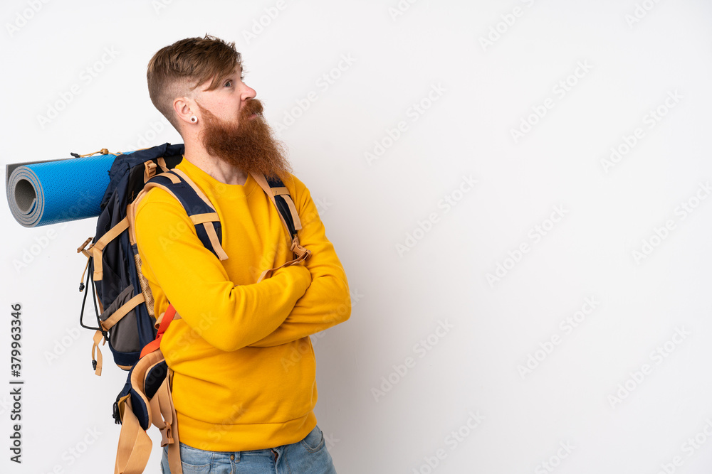 Young mountaineer man with a big backpack over isolated white background laughing Young mountaineer man with a big backpack over isolated white background laughing
