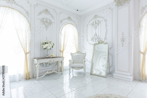 luxury royal posh interior in baroque style. very bright, light and white hall with expensive oldstyle furniture. large windows and stucco ornament decorations on the walls © 4595886