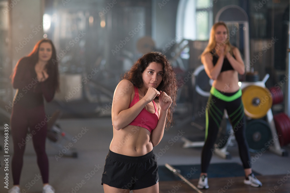 Young beautiful female athletes doing Boxing warm-up in the gym. Fitness training workout.