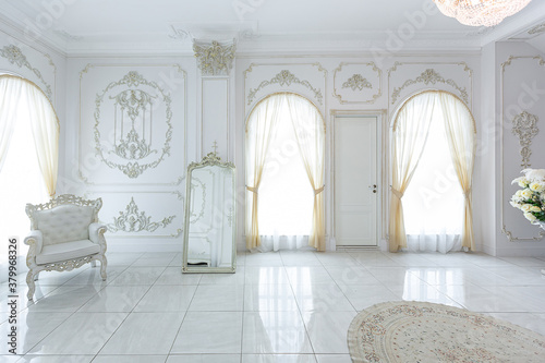 luxury royal posh interior in baroque style. very bright, light and white hall with expensive oldstyle furniture. large windows and stucco ornament decorations on the walls © 4595886