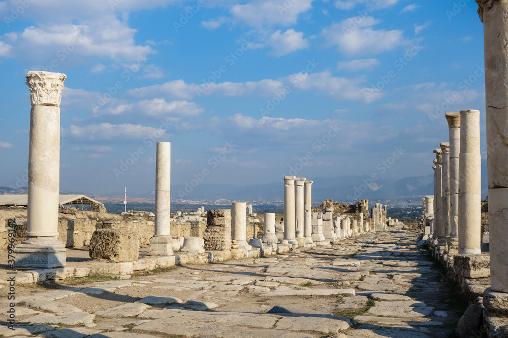 View in perspective onto empty colonnaded street in antique city Laodicea, near Denizli, Turkey. Columns made in Corinthian order. City included in Tentative List of UNESCO
