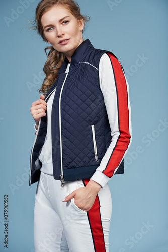 Young beautiful blonde model in fashionable clothes on a blue background. Studio fashion photography