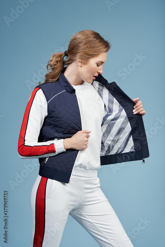 Young beautiful blonde model in fashionable clothes on a blue background. Studio fashion photography