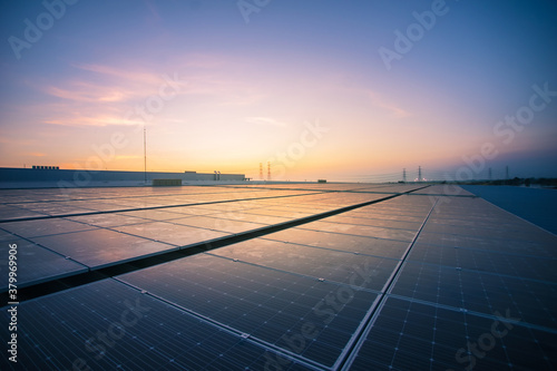 Solar panel photovoltaic install on the roof of factory under morning sky.