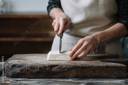 Person slicing feta cheese for spanakopita photo