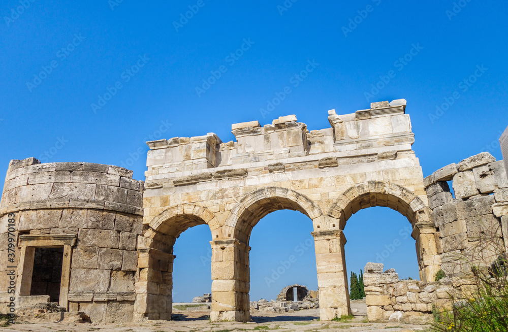 Domitian gates with towers on Frontinus street of antique city Hierapolis, Pamukkale, Turkey. Built around 84 AD from travertine blocks, some parts made from marble. Included in UNESCO List