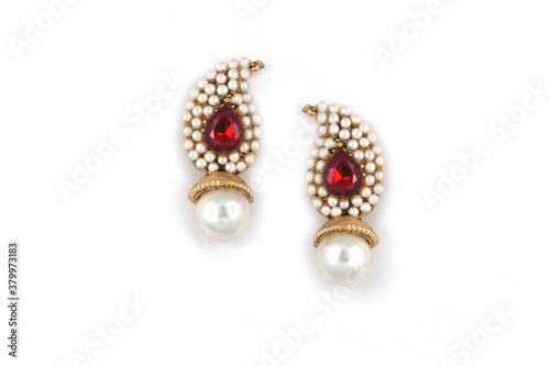 Beautiful pair of earrings pearl with red gemstone on a white background. Luxury female jewelry, Indian traditional jewellery, ,Bridal Gold earrings wedding jewellery