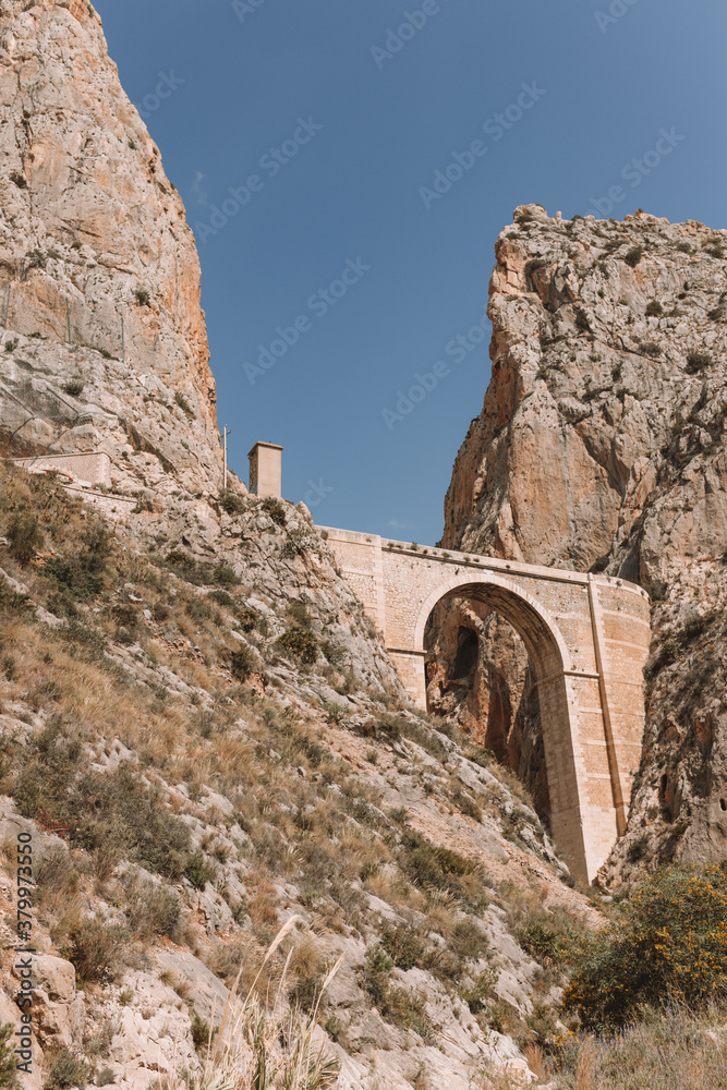Vertical shot of the rocks and bridges in the la Serra Gelada Natural Park in Spain