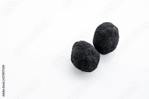 An old duck egg recipe in ash. Salty pickled duck egg in ash on a white background