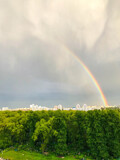 bright colored rainbow in the sky. a double rainbow of different colors appeared after the rain in the city. a beautiful and romantic natural phenomenon. raindrops are reflected in color
