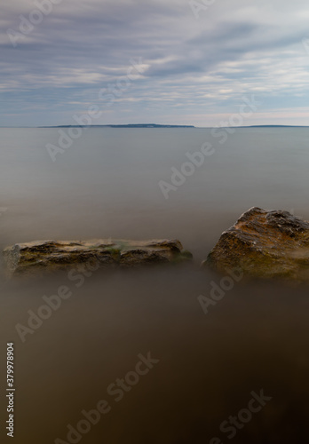 Cloudy Lake Huron and beach in the morning in summer Michigan. Long exposure