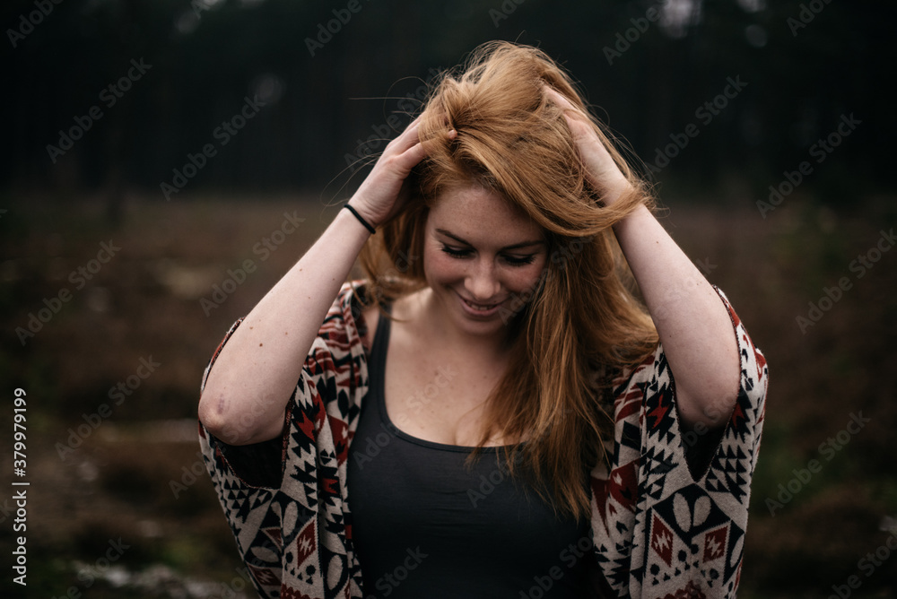 a woman playing with her red hair a woman playing with her red hair