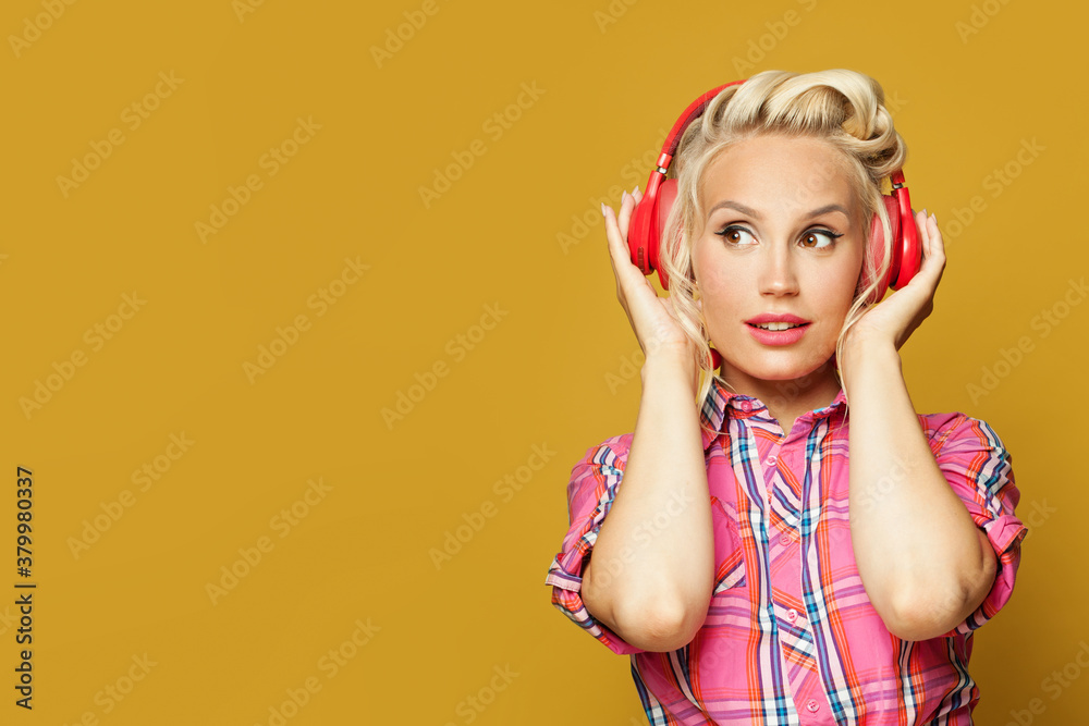 Portrait of pin-up woman with headphones on colorful yellow background Portrait of pin-up woman with headphones on colorful yellow background