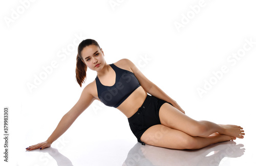 Serious woman doing pilates exercise on floor