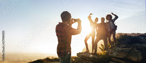 Man photographing his friends on mountain top