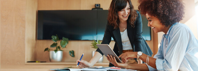 Creative female executives using digital tablet in office
