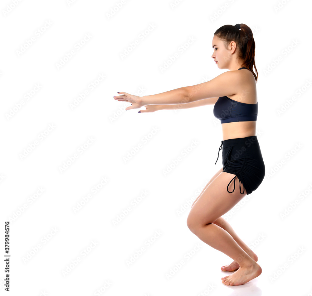 Studio portrait of sporty athletic woman squatting Studio portrait of sporty athletic woman squatting