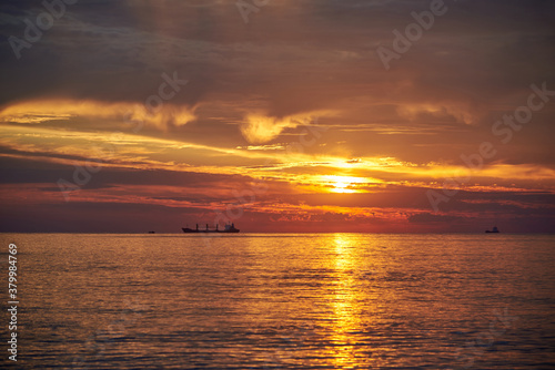 Sunset on the sea, ships standing on the horizon. © Pavlo