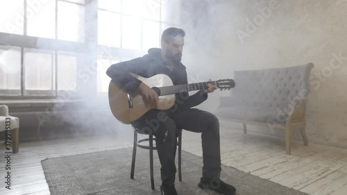 Young man playing guitar in the room