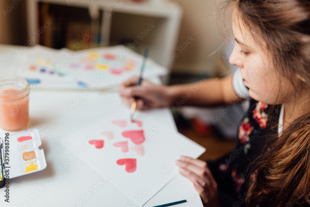 teen painting pink hearts in watercolours teen painting pink hearts in watercolours