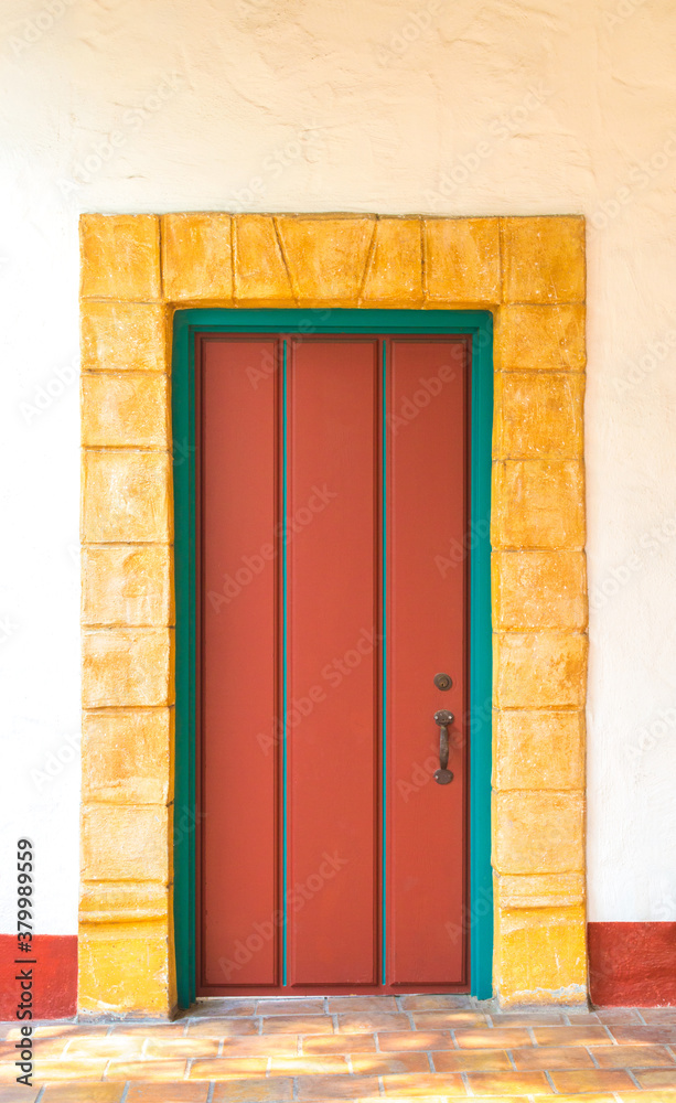 Fototapeta premium vintage red wooden door with a sandstone brick border