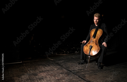 On-stage portrait of a cellist with his instrument photo