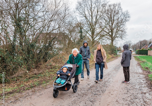 Multi-generational family walking on footpath between fields