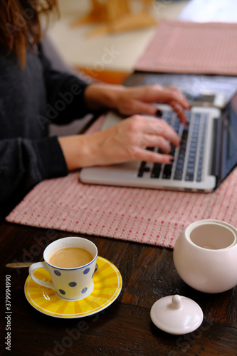 Woman using laptop computer with espresso. photo